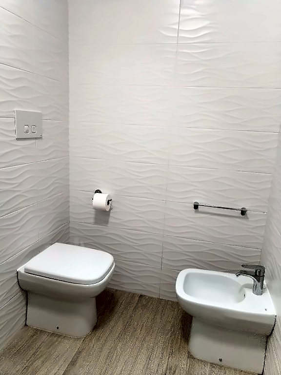 WC e bidet con piastrelle bianche a onde